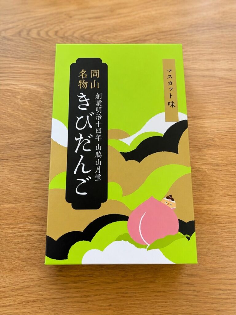 山脇山月堂のマスカット味きびだんごのパッケージ。黄緑の和柄に桃と桃太郎のデザイン